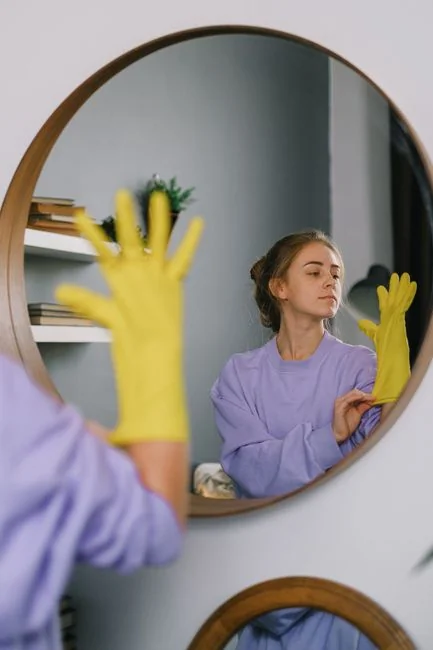 who-we-are A man in coveralls cleans a large window in a stylish, modern home interior.